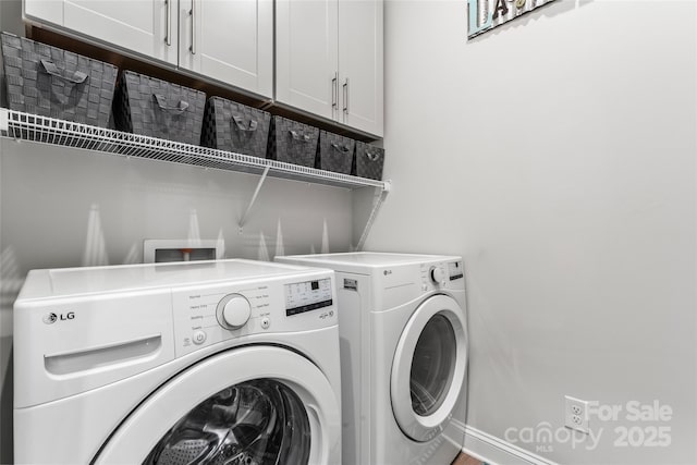 laundry area with washer and dryer and cabinets