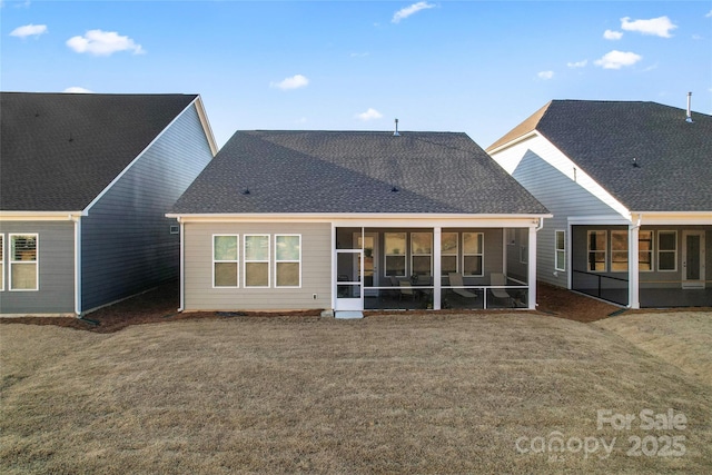 rear view of property featuring a yard and a sunroom