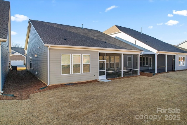 rear view of house featuring a lawn and a sunroom