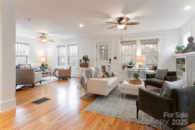 living room featuring ceiling fan, a healthy amount of sunlight, and light hardwood / wood-style floors