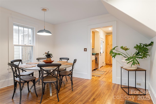 dining area featuring vaulted ceiling and light hardwood / wood-style floors