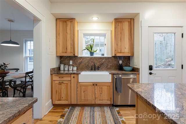 kitchen featuring hanging light fixtures, dishwasher, dark stone countertops, and tasteful backsplash