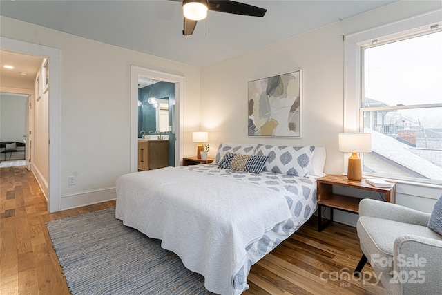 bedroom featuring ceiling fan, dark hardwood / wood-style flooring, and connected bathroom