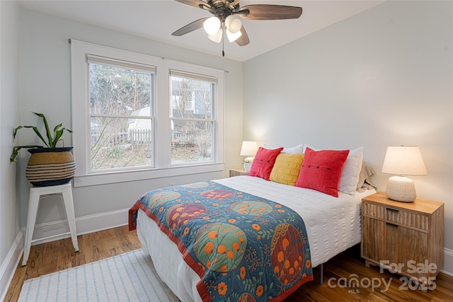 bedroom featuring dark wood-type flooring, ceiling fan, and multiple windows