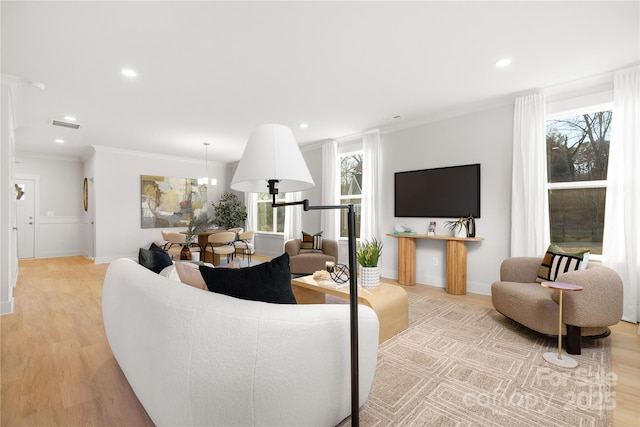 living area with ornamental molding, light wood-type flooring, visible vents, and recessed lighting