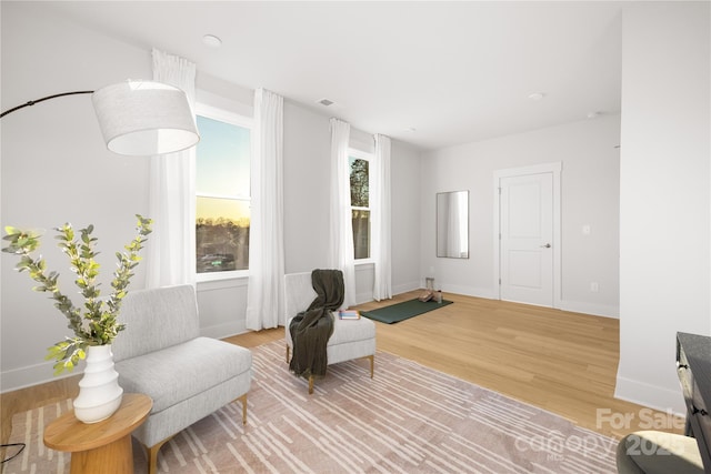 living area with light wood-style flooring and baseboards