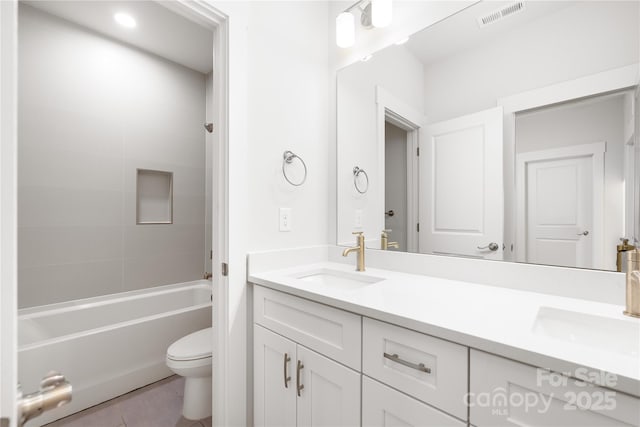 full bathroom featuring toilet, double vanity, a sink, and visible vents