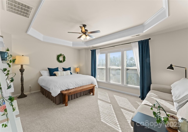 carpeted bedroom featuring ornamental molding, ceiling fan, and a tray ceiling