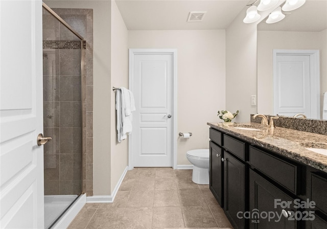 bathroom featuring tile patterned flooring, vanity, an enclosed shower, and toilet