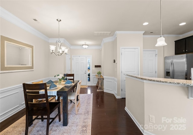 dining area featuring dark hardwood / wood-style flooring, ornamental molding, and a chandelier