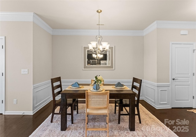 dining space with crown molding, a chandelier, and dark wood-type flooring