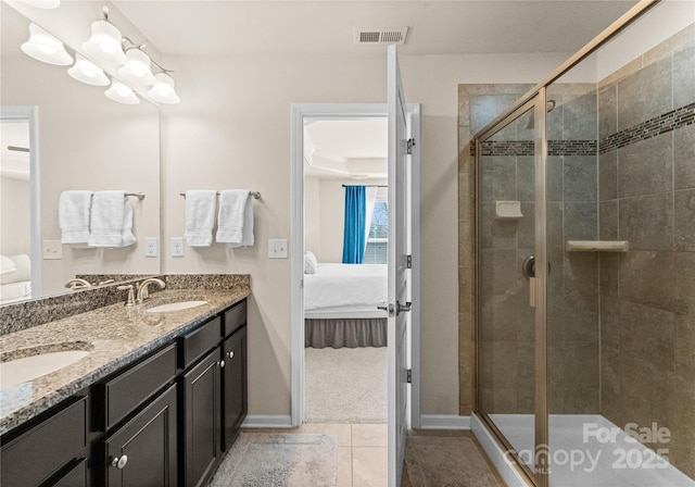 bathroom with vanity, a shower with shower door, and tile patterned flooring