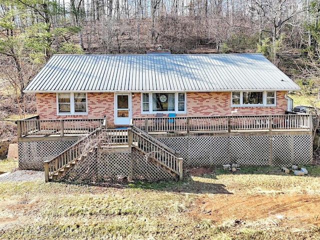 rear view of house with a deck and a lawn