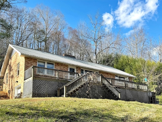 back of property with a deck and a yard