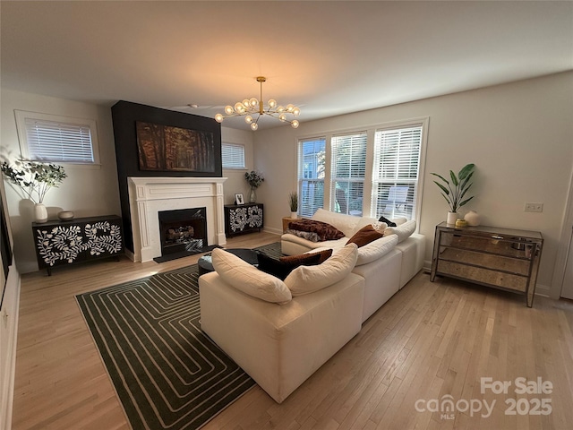 living room with a notable chandelier and light wood-type flooring