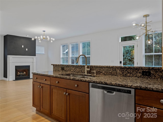 kitchen featuring dark stone counters, an inviting chandelier, and stainless steel dishwasher