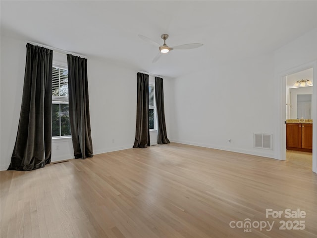 empty room with ceiling fan and light hardwood / wood-style floors