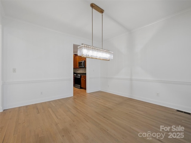 unfurnished dining area with ornamental molding and light hardwood / wood-style flooring