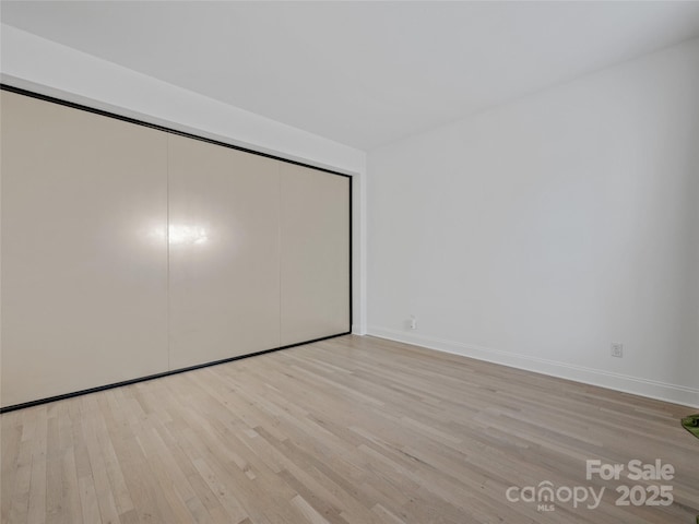 unfurnished bedroom featuring a closet and light hardwood / wood-style flooring