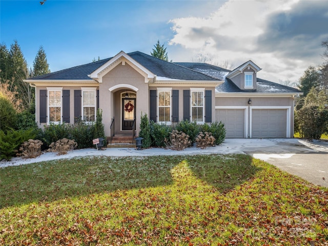 view of front of property featuring a front yard and a garage