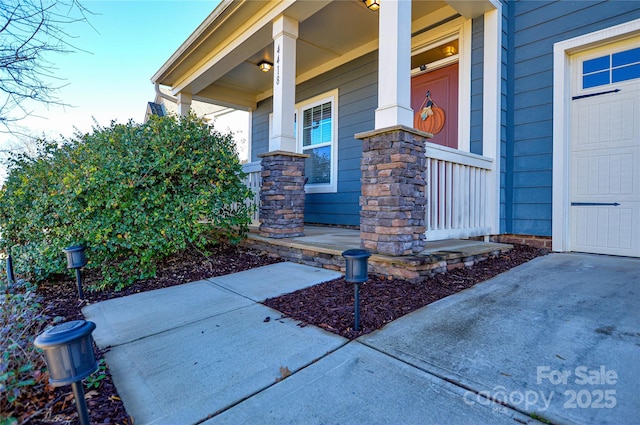 view of exterior entry featuring covered porch