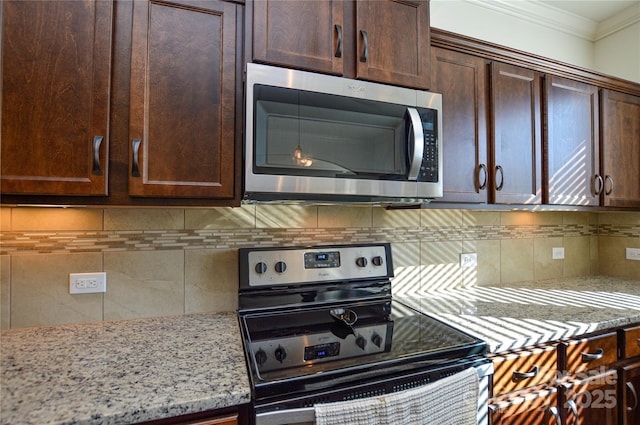 kitchen with backsplash, black range with electric stovetop, light stone counters, and crown molding