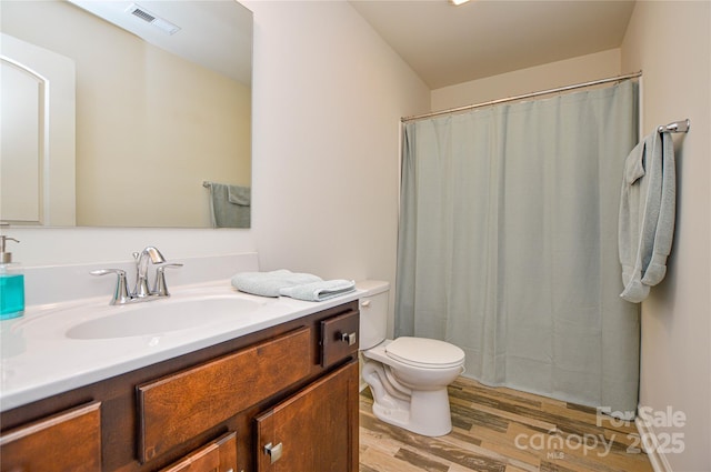 bathroom with hardwood / wood-style floors, vanity, and toilet