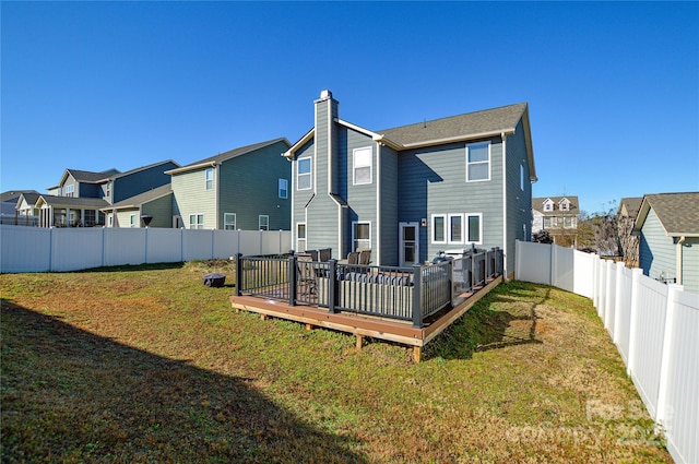 rear view of property with a wooden deck and a yard