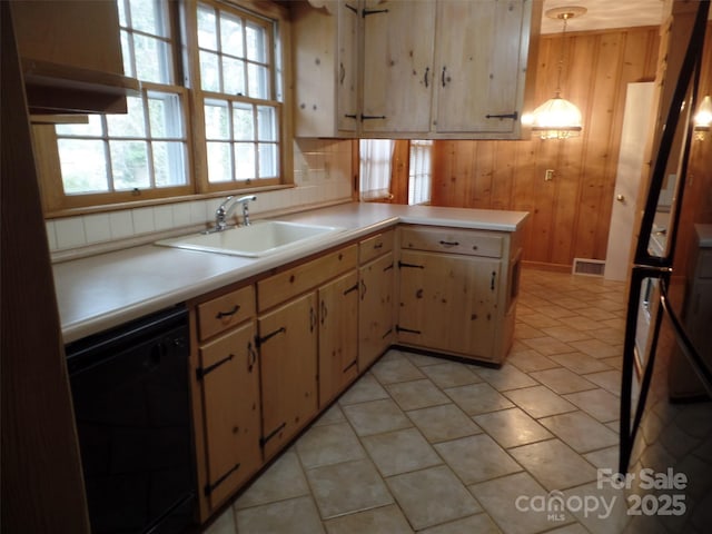 kitchen featuring wood walls, kitchen peninsula, dishwasher, hanging light fixtures, and sink