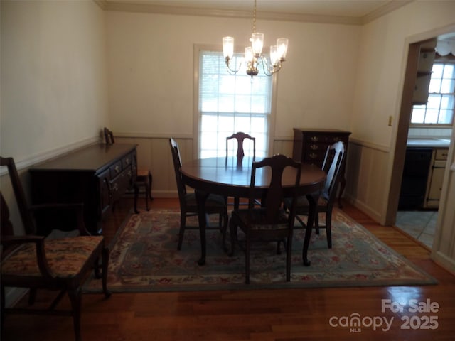 dining space featuring a chandelier, ornamental molding, and hardwood / wood-style floors