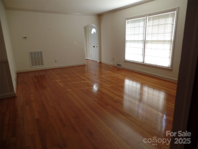 empty room with crown molding and hardwood / wood-style flooring