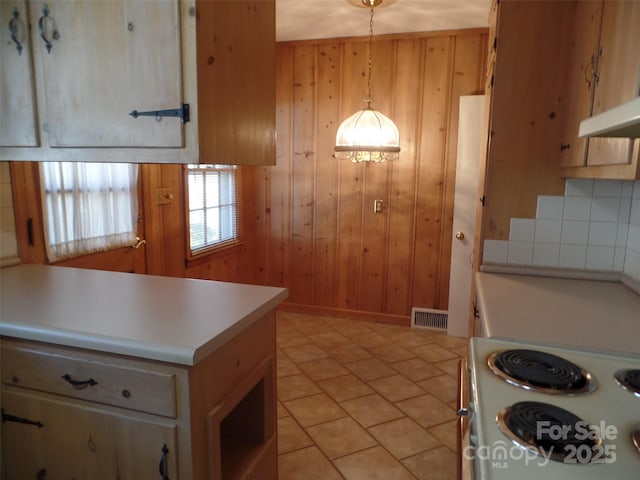 kitchen featuring hanging light fixtures, light tile patterned floors, white electric range, and wooden walls