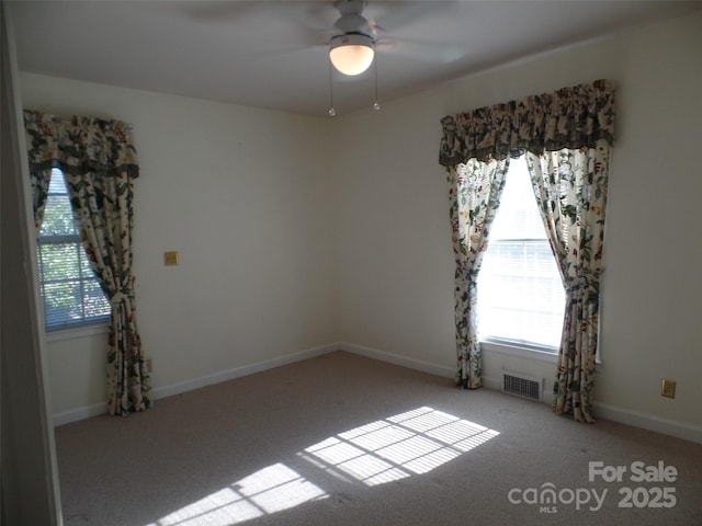 carpeted empty room with ceiling fan and a healthy amount of sunlight