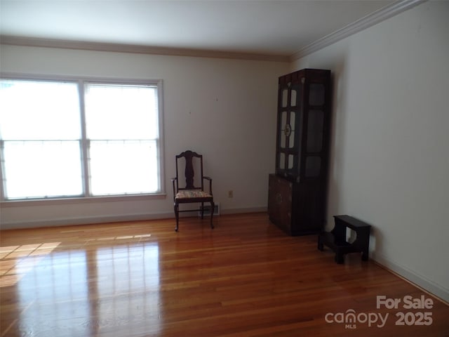 unfurnished room with ornamental molding and wood-type flooring