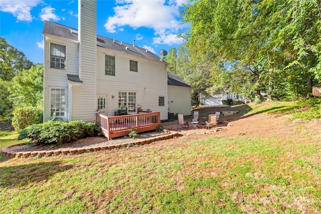 back of property with a yard and a wooden deck