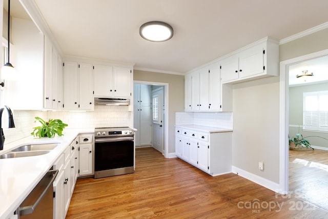 kitchen featuring light wood-type flooring, backsplash, stainless steel appliances, sink, and white cabinetry