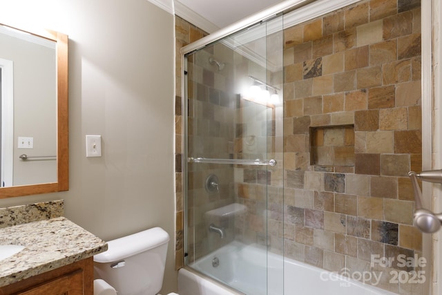 full bathroom featuring toilet, vanity, enclosed tub / shower combo, and ornamental molding