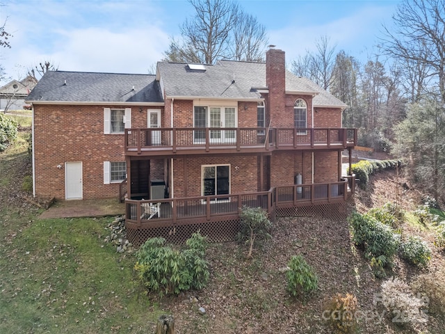 rear view of house with central AC unit, a yard, and a wooden deck