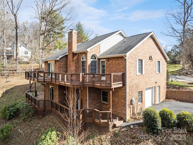 rear view of house with a garage and a deck