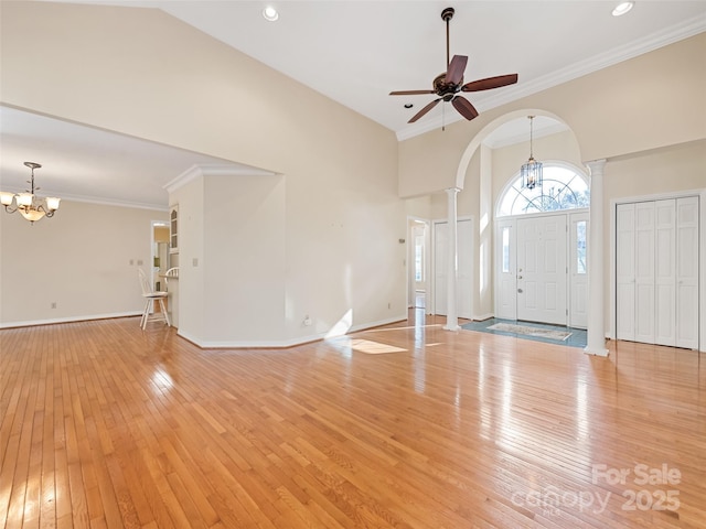 foyer with ceiling fan with notable chandelier, ornate columns, crown molding, and light hardwood / wood-style flooring