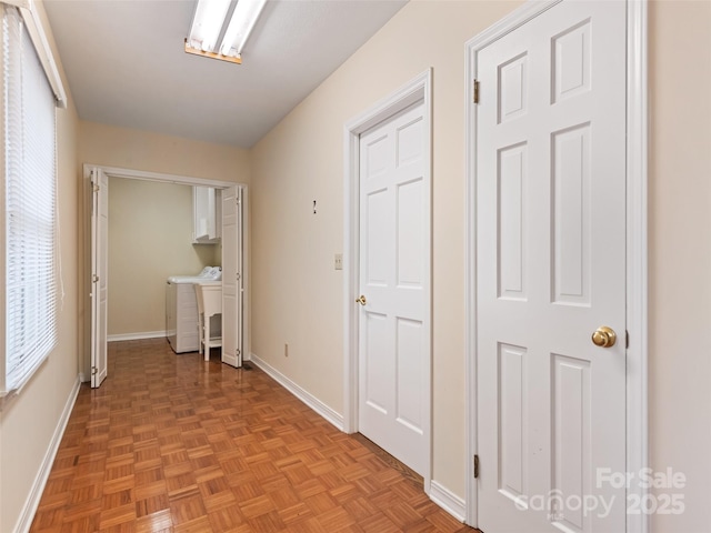 corridor featuring washer and clothes dryer and light parquet floors