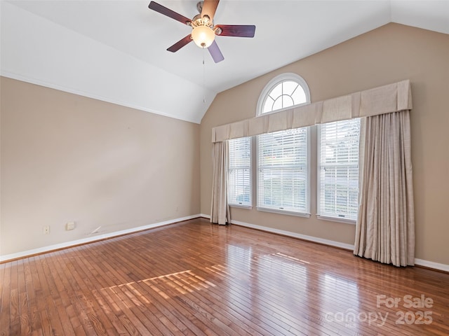 empty room with hardwood / wood-style flooring, ceiling fan, and lofted ceiling