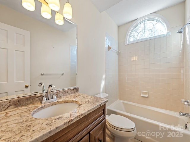 full bathroom featuring tiled shower / bath combo, toilet, and vanity