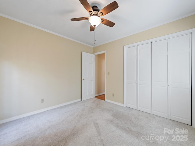 unfurnished bedroom with a closet, light colored carpet, ceiling fan, and ornamental molding