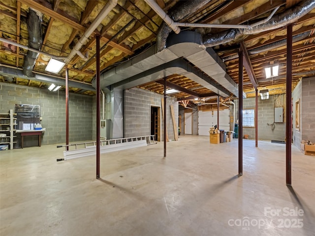 basement featuring electric panel and heating unit