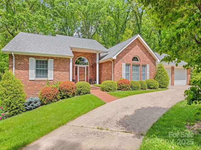 185 Oak Ridge Dr, Clyde, NC 28721 - view of front of home with a shingled roof, brick siding, a front lawn, and a garage