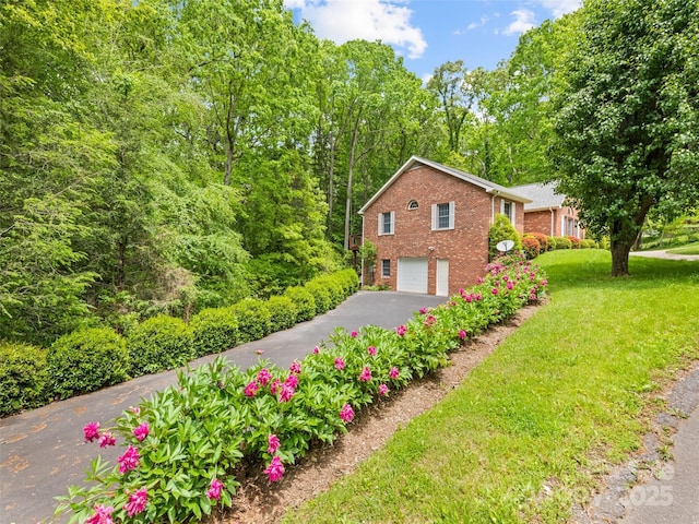 185 Oak Ridge Dr, Clyde, NC 28721 - view of side of property featuring driveway, brick siding, a garage, and a lawn