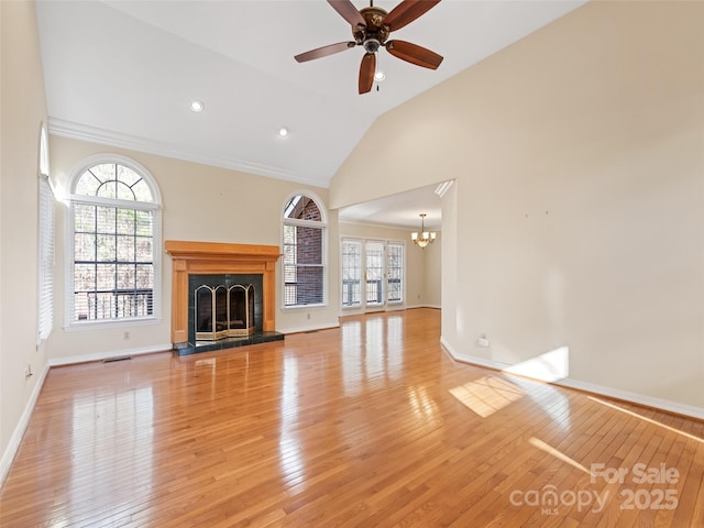 185 Oak Ridge Dr, Clyde, NC 28721 - unfurnished living room featuring a chandelier, a fireplace with raised hearth, light wood-type flooring, baseboards, and high vaulted ceiling
