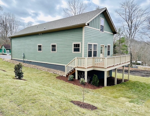 back of property with a lawn and a wooden deck