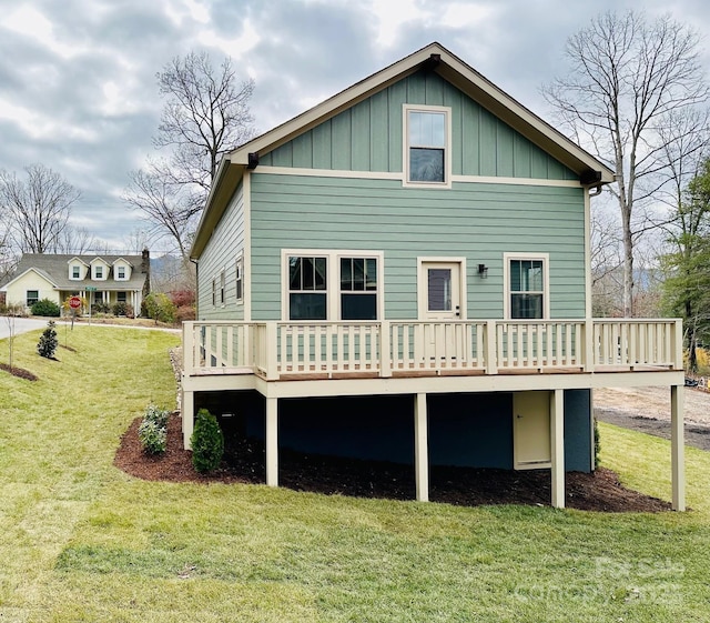 rear view of house featuring a yard and a wooden deck